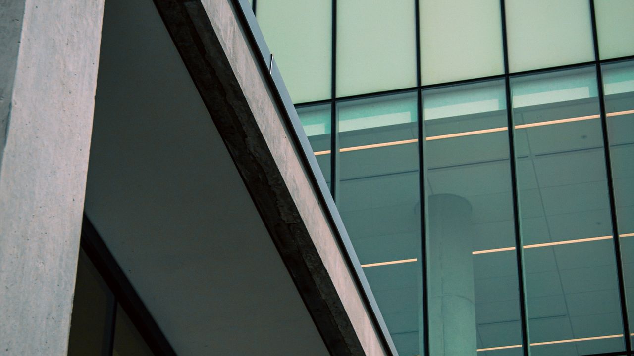 Edificio de oficinas moderno con paneles de vidrio y hormigon, imagen para guia de costos ocultos al comprar en pozo