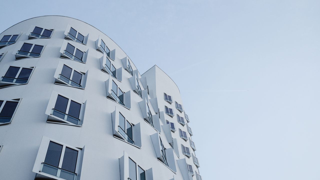 Edificio contemporaneo con arreglo unico de ventanas en Dusseldorf, imagen para guia de dolar y construccion en pozo